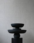 Stack of black ceramic bowls on a gray background from 101 Copenhagen at Spacio retail stores in Mumbai & Kolkata.