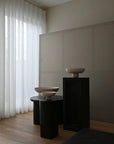 Three ceramic bowls on black pedestals against a neutral wall with white curtains from 101 Copenhagen at Spacio retail stores in Mumbai & Kolkata.