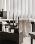 Modern interior with dark wooden furniture, white curtains, and candles.