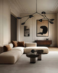 Modern living room with a beige sectional sofa, round coffee table, and decorative wall art.