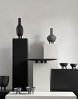 A group of 101Cph Duck Fat Dark Grey 111281 vases by 101 Copenhagen on a table.