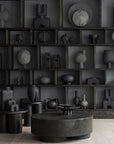A room with many 101Cph Duck Fat Dark Grey 111281 vases and a coffee table in a dark grey color.