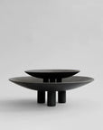 Two 101Cph Duck Plate Big Coffee 214049 black bowls, inspired by Scandinavian home decor, sitting on top of each other.