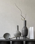 A 101Cph Duck Slim Coffee 111280 table adorned with ceramic vases and books.