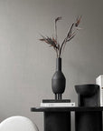 A ceramic table with a 101Cph Duck Slim Coffee 111280 in Copenhagen Duck Slim design and a second 101Cph Duck Slim Coffee 111280 in coffee colour placed on top, all from the brand 101 Copenhagen.