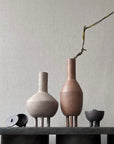 Quirky vases, including the 101Cph Duck Vase Fat Taupe 213045 by 101 Copenhagen, displayed on a table next to a wall.