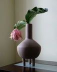 A quirky 101Cph Duck Vase Fat Taupe 213045 with a pink flower in it.