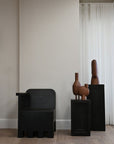 A room with several 101Cph Duck Vase Slim Terracotta 213044 by 101 Copenhagen and a wooden floor adorned in terracotta color.