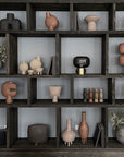 A shelf with a lot of different vases on it, including a terracotta colored 101Cph Duck Vase Slim Terracotta 213044 from the brand 101 Copenhagen.