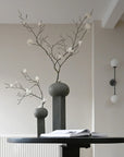 Two 101Cph Empire Big Dark Grey 223034 vases, ceramic architectural references, positioned on a table in a room.