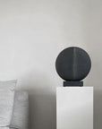 In an interior setting, a whimsical 101Cph Guggenheim Mini Black 111126 from 101 Copenhagen sits atop a white pedestal, resembling quirky vases.