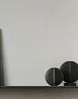 A wooden shelf with two 101Cph Guggenheim Mini Black 111126 vases and a whimsical painting on it, creating an intriguing interior setting.
