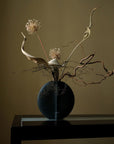 A 101Cph Guggenheim Petit Black 213042 vase with flowers in it, showcasing the elegance of the black color, sits gracefully on a table.