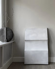 Modern interior with a grey ceramic vase from 101 Copenhagen and a concrete wall art piece.