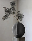 Decorative vase with a branch on a neutral background from 101 Copenhagen at Spacio retail stores in Mumbai & Kolkata.