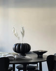 A 101Cph Medusa Tray Mini Coffee 221064 with black chairs and a ceramic pumpkin vase.