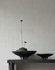 The 101Cph Medusa Tray Mini Coffee 221064, made of ceramic, holds two black bowls on a table next to a wall.