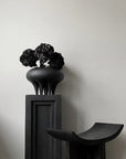 A 101 Copenhagen Medusa Vase Big Coffee 221061 sits on top of a black pedestal.