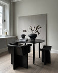 A dining room with a black table and chairs adorned with a 101 Copenhagen Medusa Vase Big Coffee 221061.
