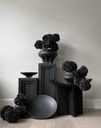 A group of 101Cph Medusa Vase Big Coffee 221061 vases by 101 Copenhagen on a wooden floor.
