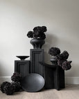 A collection of 101Cph Medusa Vase Mini Coffee 221062 by 101 Copenhagen on a wooden floor.