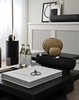 Modern interior with black table, decorative items, and a white wall.