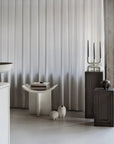 Modern interior with a curtain, table and decor accessories on coffee colour pedestals from 101 Copenhagen