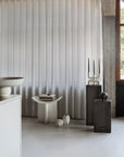 Modern interior with a curtain, table and decor accessories on coffee colour pedestals from 101 Copenhagen