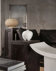 Modern interior with a dark sofa, white vase, textured walls and decor accessories on pedestal (plinths) from 101 Copenhagen