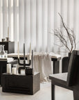 Modern interior with black furniture, a plant against a white curtain and stands on a pedestal (plinth) from 101 Copenhagen