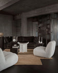 Modern living room with dark walls, a brown rug, and gray furniture.