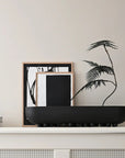 Decorative setup with 101 Copenhagen Shinju platter& black and white framed art on a shelf against a light wall.