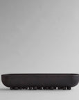 Black ceramic bowl on a light gray background from 101 Copenhagen at Spacio retail stores in Mumbai & Kolkata.