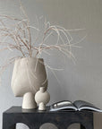 A 101 Copenhagen Sphere Bubl Mini Sand 203008 vase, placed on a table next to a book.