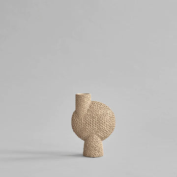 A small woven 101Cph Sphere Bubl Shisen Medio Sand 231018 vase from the 101 Copenhagen Sphere collection on a grey background.