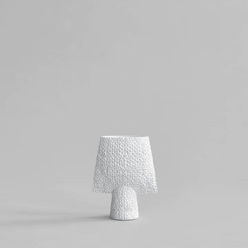 A 101Cph Sphere Square Shisen Mini Bone White 231012 table lamp on a grey background, showcasing a decorative and sculptural manner with its bone white finish.