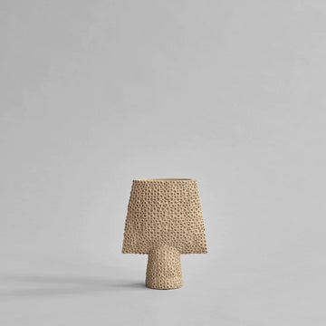 A small 101Cph Sphere Square Shisen Mini Sand 231016 vase with a sand finish on a grey background by 101 Copenhagen.