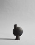 Black ceramic vase on a light gray background from 101 Copenhagen at Spacio retail stores in Mumbai & Kolkata.