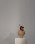 Vase with grapes on a sculptural vase against a gray background from 101 Copenhagen at Spacio retail stores in Mumbai & Kolkata.