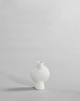 The 101Cph Sphere Vase Bubl Mini Bubble White 202003, a white vase from the 101 Copenhagen brand, elegantly sits on a gray surface.