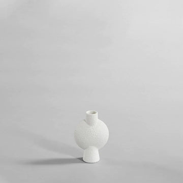The 101Cph Sphere Vase Bubl Mini Bubble White 202003, a white vase from the 101 Copenhagen brand, elegantly sits on a gray surface.