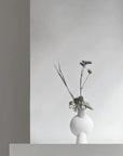A 101Cph Sphere Vase Bubl Mini Bubble White 202003 by 101 Copenhagen, a Scandinavian brand, sits on a shelf in a room.