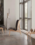 A room furnished with a wooden chair and adorned with an ochre finish, showcasing the 101Cph Sphere Vase Bubl Mini Ocher 111180 from the renowned Scandinavian brand, 101 Copenhagen.