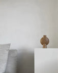 A 101 Copenhagen brand's 101Cph Sphere Vase Bubl Mini Ocher 111180 sits on top of a white pedestal.