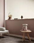 Modern interior with a white sofa, small round table, and decorative items against a wall.