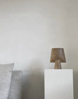 A white couch with a lamp on top of it, accented by an elegant 101Cph Sphere Vase Square Mini Ocher 111181 from 101 Copenhagen.