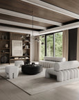 Modern living room with a white sofa, coffee table, and bookshelves.