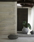 Minimalist interior with stone walls, a plant, and decorative vases from 101 Copenhagen at Spacio retail stores in Mumbai & Kolkata.