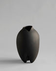 Black vase with a unique design on a gray background from 101 Copenhagen at Spacio retail stores in Mumbai & Kolkata.