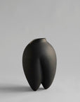 Black vase on a gray background from 101 Copenhagen at Spacio retail stores in Mumbai & Kolkata.